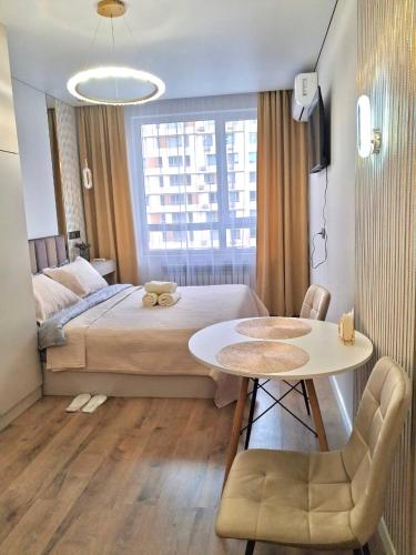 a bedroom with a bed and a table and a table and chairs at Rams city квартира in Zhezdi