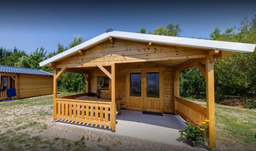 een houten prieel met een veranda in een tuin bij Camping Suderse - De Lyster in Workum