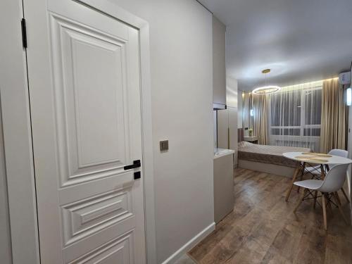 a white door in a room with a table and a tablektop at Rams city квартира in Zhezdi