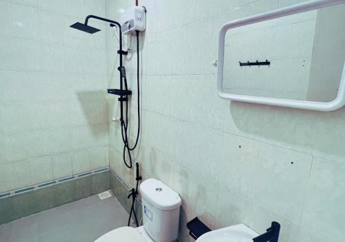 a bathroom with a toilet and a shower at Kandoo Cozy Family Room in Huraa