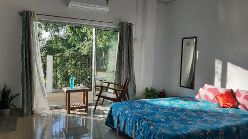 a bedroom with a bed and a large window at Peace Abode Vista in Dibrugarh