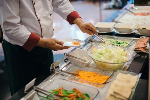 a chef is preparing food in a kitchen at City Garden Hotel Makati in Manila