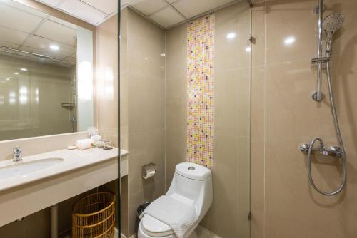 een badkamer met een douche, een toilet en een wastafel bij Maple Hotel in Bangkok