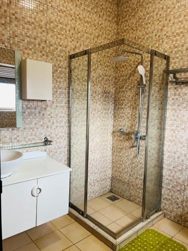 a bathroom with a shower and a sink at Las Vegas Garden Hotel-Kampala in Kampala