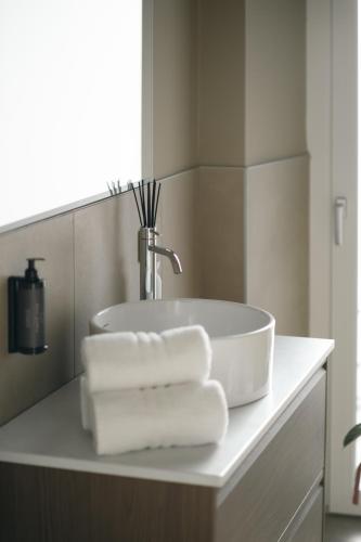 a bathroom sink with towels on a counter at The Tower Premium Apartment - Beams & Views - 3 Min Walk to Bernina Express & Station in Tirano