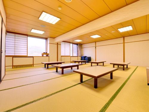 an empty room with benches and tables in it at Hachimantai Mountain Hotel & Spa in Hachimantai