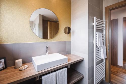 a bathroom with a white sink and a mirror at Hotel Garni Andrianerhof in Andrian
