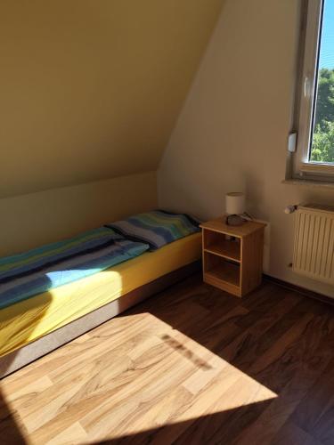 een kleine slaapkamer met een bed en een kleine tafel bij Ferienhaus am See in Godendorf