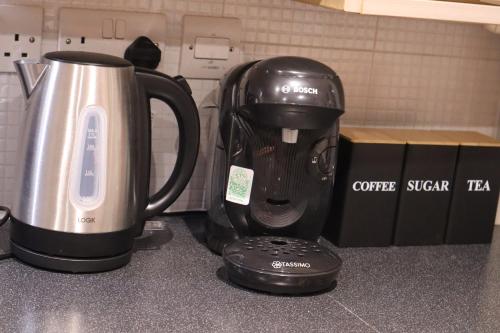 une cafetière posée sur un comptoir à côté d'une tasse dans l'établissement Duxford Haven, à Duxford