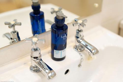 a bottle of soap is sitting on a bathroom sink at Cleish Apartment in Edinburgh