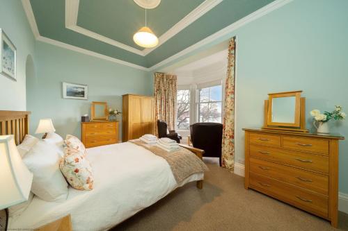 a bedroom with a bed and a dresser and a mirror at Cleish Apartment in Edinburgh