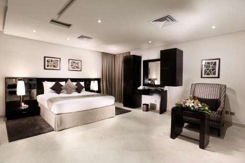 a bedroom with a bed and a chair and a table at سدو بوتيك الخبر in Al Khobar