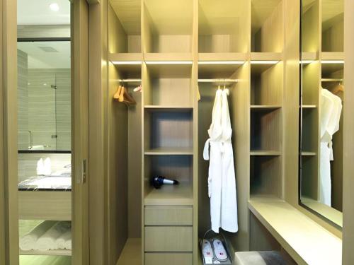 a bathroom with a walk in closet with a mirror at Huafa Executive Apartment Hotel Zhuhai in Cheoc Ca Chün
