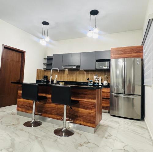 a kitchen with a counter and a refrigerator at Mazatlán Cervo vacacional in Mazatlán
