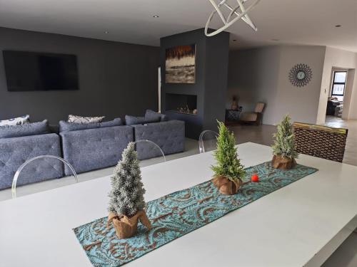 een woonkamer met een blauwe bank en bomen op een aanrecht bij Tee Off House in Parys