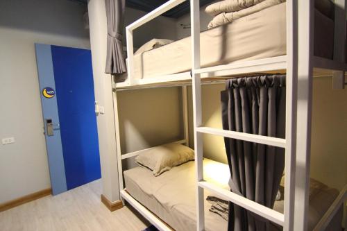 a room with bunk beds with a bed in it at The Moon Hostel Huahin in Hua Hin