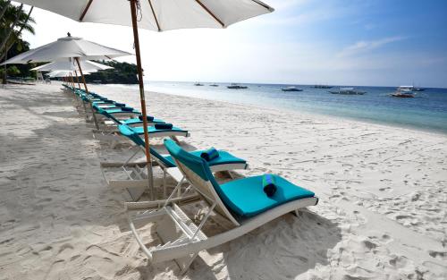 a row of chairs and umbrellas on a beach at Henann Resort Alona Beach in Panglao