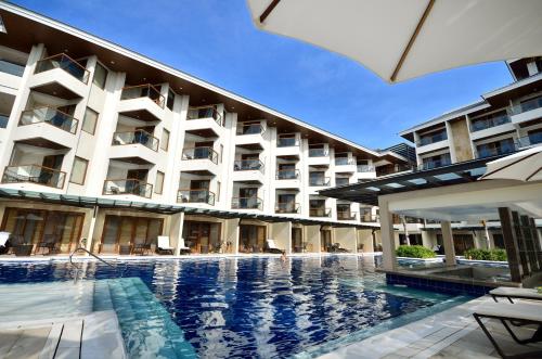 a hotel with a swimming pool in front of a building at Henann Resort Alona Beach in Panglao