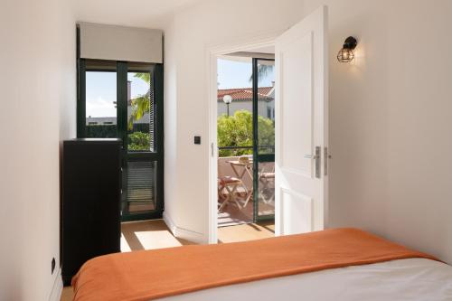 a bedroom with a bed and a door to a balcony at Varandas do Funchal I by An Island Apart in Funchal