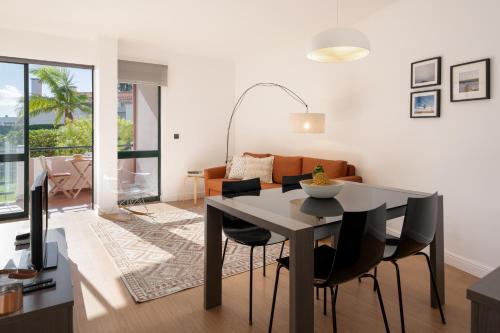 a dining room and living room with a table and chairs at Varandas do Funchal I by An Island Apart in Funchal