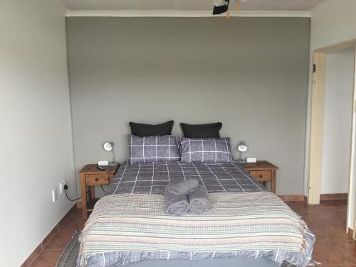 a bedroom with a bed with a striped blanket and pillows at Golden Mile Estate Self Check Inn in eMalahleni