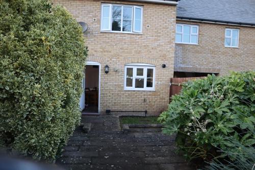 une maison en briques avec un escalier menant à la porte d'entrée. dans l'établissement Duxford Haven, à Duxford