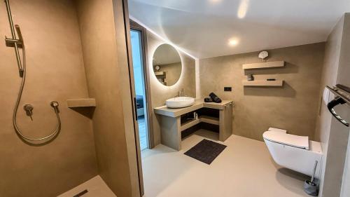 een badkamer met een wastafel, een toilet en een spiegel bij Eosea Helios in Ierissos