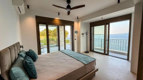 een slaapkamer met een bed en glazen schuifdeuren bij Eosea Helios in Ierissos