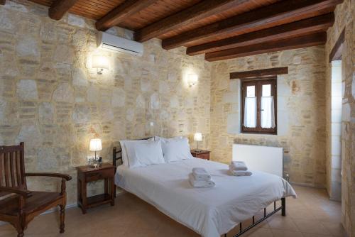 una camera da letto con un letto in un muro di pietra di Luxurious Villa with Private Pool ad Arménoi