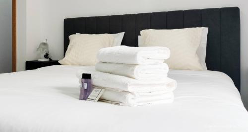 une pile de serviettes empilées sur un lit dans l'établissement Casa da Aldeia - Monte Redondo, à Figueira de Lorvão