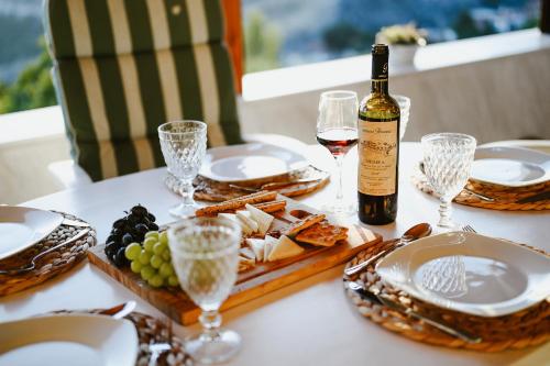 un tavolo con una bottiglia di vino e un piatto di cibo di Panoramic View Villa a Stagiates