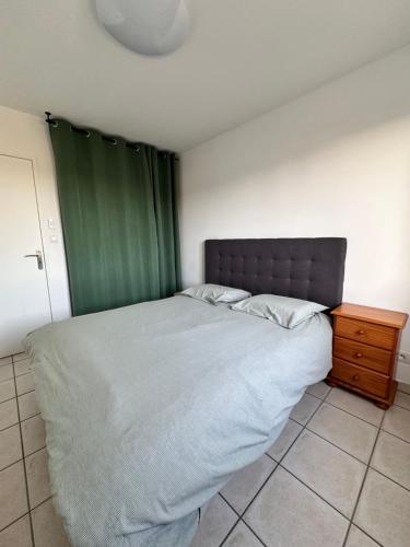 een slaapkamer met een groot bed en een groen gordijn bij L Escapade Rurale in Usseau