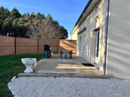 een patio met 2 stoelen en een grill naast een gebouw bij L Escapade Rurale in Usseau