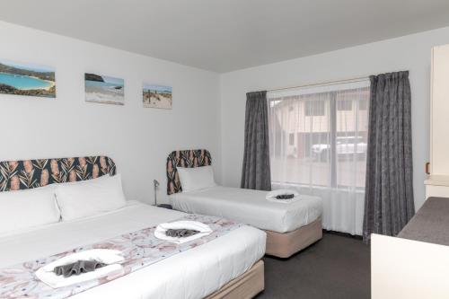 a bedroom with two beds and a window at Amber Court Motel Nelson in Nelson