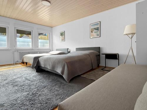deux lits dans une chambre avec des murs et des fenêtres blancs dans l'établissement Stuttgart Sky & Comfort Apartments, à Stuttgart