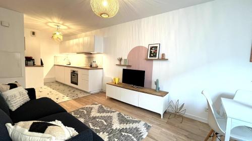 een woonkamer met een bank en een keuken bij Le Cours des Arts in Nantes