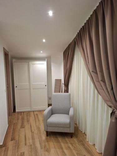 een woonkamer met een stoel en een raam bij Rosa's House in Vazzano