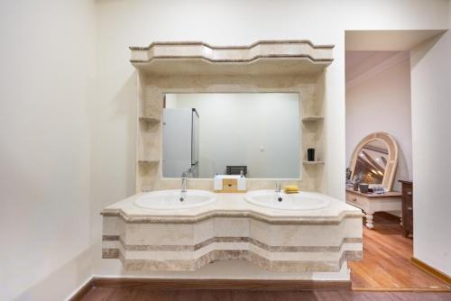 une salle de bain avec un lavabo en pierre et un miroir dans l'établissement Bloomfields al-Fujairah 4BR Villa, Beach Access, à Rūl Ḑadnā