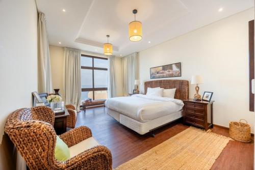 une chambre avec un lit et des chaises dans une pièce dans l'établissement Bloomfields al-Fujairah 4BR Villa, Beach Access, à Rūl Ḑadnā