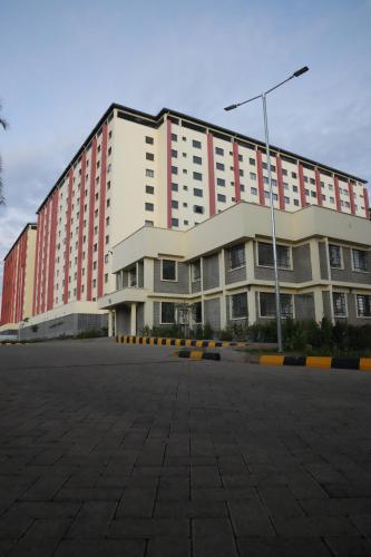 een groot gebouw met een parkeerplaats ervoor bij Modern 2-Bedroom Apartment Near Kisumu CBD, Free WiFi, Parking & Security in Kisumu
