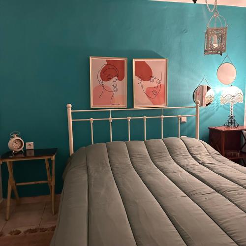 a bedroom with a bed with three pictures on the wall at Garden house in Arta