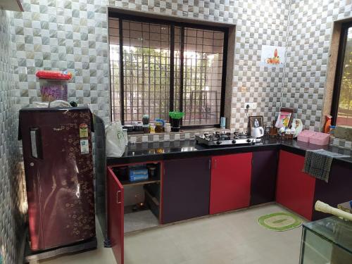 eine Küche mit Kühlschrank und Arbeitsplatte in der Unterkunft Om sai villa in Neral