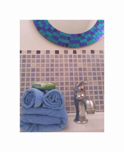 a bathroom with blue towels and a sink and a mirror at Il Rosciolo Sulla Francigena in Formello