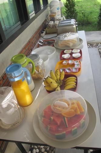 a table topped with plates of fruit and juice at Sweet Dreams in Phetchaburi