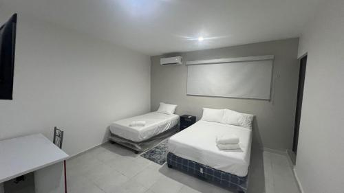 a small room with two beds and a projection screen at Departamentos 597 in Mérida