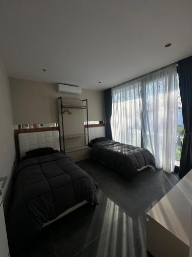 a bedroom with two beds and a large window at ZEN Villa in Rrushkull