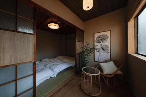 a small room with a bed and a chair at New Open KIKUNOYA-sora- in Nagoya