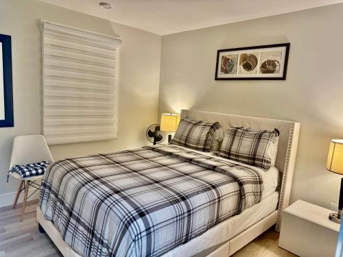 een slaapkamer met een bed met een geruite deken bij Platinum Homes Stylish 3BR Home Near Moncton, Dieppe Airport Free Parking in Dieppe