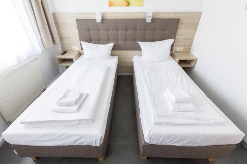 two beds in a small room with two beds at Hotel Pension Odin in Berlin