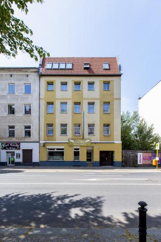 a yellow building on the side of a street at Hotel Pension Odin in Berlin